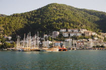 Olu Deniz.  Approaching Fethiye harbour from Gemiler Island  moored boats and waterside buildings with tree covered hillside behind.Turkish rivieraAegeancoastcoastalSt NicholasOludenizseashore...