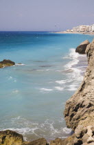 Deserted beach with rocks and clear  aquamarine water at Ixia beach resort looking East towards Rhodes Town with dark blue sea beyond.Aegeancoastcoastalformer Ottoman territorylocation for Guns o...