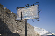 Rhodes Town.  Old Town walls with metal Greek sign in foreground and Mandraki harbour and partly seen cruise ship behind.AegeancoastcoastalFormer Ottoman territoryearlySummer seasonlocation of...