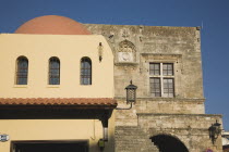 Argykastron Square  also known as Hippocrates Square.  Former Tribune of Commerce building at right of ochre and cream coloured building with domed roof in afternoon sun.Aegeancoast  coastalFormer...