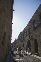 Old Town.  Tourist group on Odos Ippoton or Street of the Knights  reputedly the oldest preserved Medieval street in Europe.  UNESCO World Heritage Site. AegeanRodicoast coastalpackage holiday res...