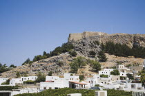 Lindos.  The Akropolis on rocky hill top with whitewashed houses of Lindos spread out below. AegeanGreekSummer seasonRodicoast coastalpackage holidaytrip destinationDestinations ElladaSouther...