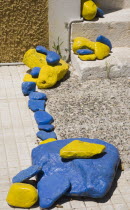 Pythagorio.  Blue and yellow painted stones decorating entrance to traditional house. AegeanGreek IslandsPythagorionSummerseacoast coastalresortholidaypackagetripDestination Destinations El...