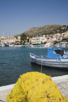 Pythagorio.  Fishing nets on harbour side with boats and view to west of Pythagorio waterfront beyond.AegeanGreek IslandsPithagorion Pythagorioncoast coastalseaSummerpackageholidayresortvaca...