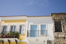 Pythagorio.  Traditional yellow and white painted apartments for holiday rental with blue and white window shutters  metal balconies and flower filled window boxes.North Eastern AegeanGreek Islands...