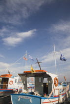 Pythagorio.   Blue  white and red painted fishing boats with flags and cross on cabin.North Eastern AegeanGreek IslandsPithagorion Pythagorioncoast coastalseaSummerpackageholidayresortvacati...