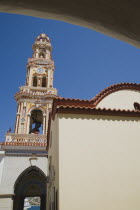 St Michael Panormitis monastery in Southern Symi.  Site of pilgrimage from the 12th Century.  Highly decorated Baroque bell tower against bright summer blue sky.AegeanGreek IslandsSimicoast coasta...