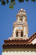 St Michael Panormitis monastery in Southern Symi.  Site of pilgrimage from the 12th Century.  Highly decorated Baroque bell tower and roof detail against bright summer blue sky.AegeanGreek IslandsS...