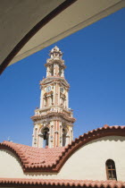 St Michael Panormitis monastery in Southern Symi.  Site of pilgrimage from the 12th Century.  Highly decorated Baroque bell tower and roof detail against bright summer blue sky.AegeanGreek IslandsS...