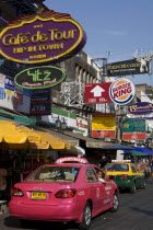 Thailand, Bangkok, Khaosan Road, Pink Taxi parked beneath colourful advertising signs.