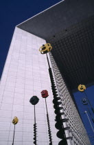 France, Ile de France, Paris, The Grand Arch in La Defence with colourful sculpture in the foreground.