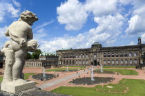 GERMANY, Saxony, Dresden, The central Courtyard and Picture Gallery of the restored Baroque Zwinger Palace gardens busy with tourists seen from the statue lined Rampart originally built between 1710 a...