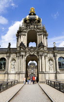 GERMANY, Saxony, Dresden, The Crown Gate or Kronentor of the restored Baroque Zwinger Palace with tourists walking through originally built between 1710 and 1732 after a design by Matthus Daniel Ppp...