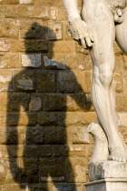 ITALY, Tuscany, Florence, Shadow of the replica Renaissance statue of David by Michelangelo on the wall of the Palazzo Vecchio in the Piazza della Signoria.