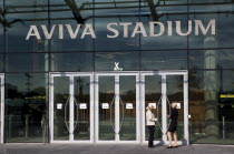 Ireland, County Dublin, Dublin City, Ballsbridge, Lansdowne Road, Women smoking outside the Aviva 50000 capacity all seater Football Stadium designed by Populus and Scott Tallon Walker. A concrete and...