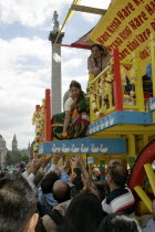 Religion, Hindu, Worship, London Rathayatra celebrations in Trafalgar Square. People handing out offerings during festival. Nelsons Column behind.