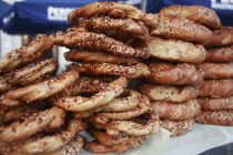 Poland, Krakow, Obwarzaneck, twisted rings of bread strewn with poppy sale for sale from street vendor's stall.