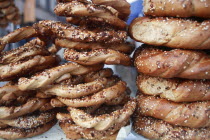 Poland, Krakow, Obwarzaneck,twisted rings of bread strewn with poppy sale for sale from street vendor's stall.