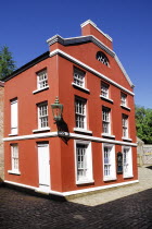 Ireland, County Tyrone, Omagh, Ulster American Folk Park, red coloured house in the reconstructed 19th century American streetscape.