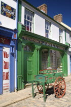 Ireland, County Tyrone, Omagh, Ulster American Folk Park, 19th century Ulster street with Victorian shopfront and fish cart.