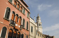 Italy, Veneto, Venice, Centro Storico, Restored facade of building painted a terracotta colour with multiple arched windows in late summer sun.