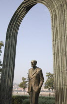 Hungary, Pest County, Budapest, statue of standing man beneath arch beside the River Danube.