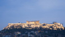 Greece, Attica, Athens, View towards the Acropolis on hilltop above Athens illuminated at dusk.