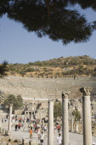 Turkey, Izmir Province, Selcuk, Ephesus, Crowds of tourists visiting ancient city of Ephesus on the Aegean sea coast with amphitheatre part seen behind. 