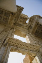 Turkey, Izmir Province, Selcuk, Ephesus, Roman Library of Celsus facade. Angled view looking up at decoratively carved roof and doorway.