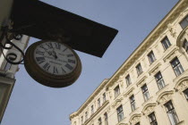 Austria, Vienna, Clock and watchmaker sign with part seen exterior facade of Empire era building behind.