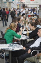 Austria, Vienna, Mariahilf District, Customers at line of busy outside cafe tables.  