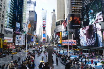 USA, New York, Manhattan, People walking in Times Square at the junction of 7th Avenue and Broadway below buildings with advertising on large video screens.