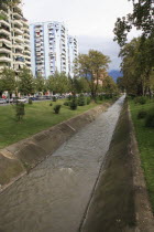 Albania, Tirane, Tirana, River Lana running past apartment blocks.