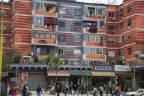 Albania, Tirane, Tirana, Colourful apartment buildings with shops below.