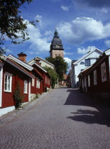 Sweden, Sodermanland, Strangnas, Cobbled street lined by wooden houses leading to Domkyrkan Cathedral.