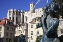 Portugal, Estremadura, Lisbon, Statue on the fountain in Rossio Square with Carmo Convent in the background.