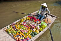 Vietnam, North, Floating market, woman selling fruit & vegetables from a boat.