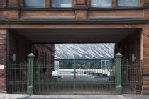 Ireland, North, Belfast, Titanic Quarter, Visitor centre designed by Civic Arts & Eric R Kuhne, seen through old gates of Harland and Wolff.