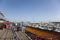 England, East Sussex, Brighton, View along the boardwalk over boats moored in the Marina.