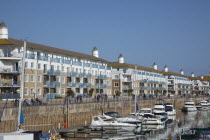 England, East Sussex, Brighton, view over boats moored in the Marina with apartment buildings behind.