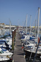 England, East Sussex, Brighton, view over boats moored in the Marina with apartment buildings behind.