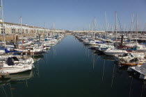 England, East Sussex, Brighton, view over boats moored in the Marina with apartment buildings behind.