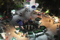 Mexico, Federal District, Mexico City, View onto Alameda park at night from Torre Latinoamericana with green and white striped roof awnings of street stalls below.