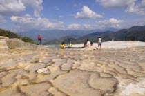 Mexico, Oaxaca, Hierve el Agua, Tourists beside limestone pool.