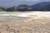 Mexico, Oaxaca, Hierve el Agua, Mountainous landscape with limestone pools in the foreground.