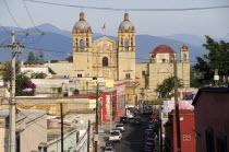 Mexico, Oaxaca, View towards church of Santo Domingo over street and rooftops of surrounding buildings.