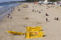 England, Dorset, Bournemouth, View over beach with families sunbathing and temporary Life Guard station in the foreground.