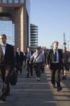 England, London, Early morning commuters crossing London Bridge towards the City Financial district.