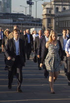 England, London, Early morning commuters crossing London Bridge towards the City Financial district.