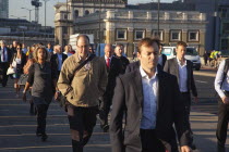 England, London, Early morning commuters crossing London Bridge towards the City Financial district.